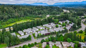 Aerial Exterior of maple crossing and surrounding areas, dense forest behind community.